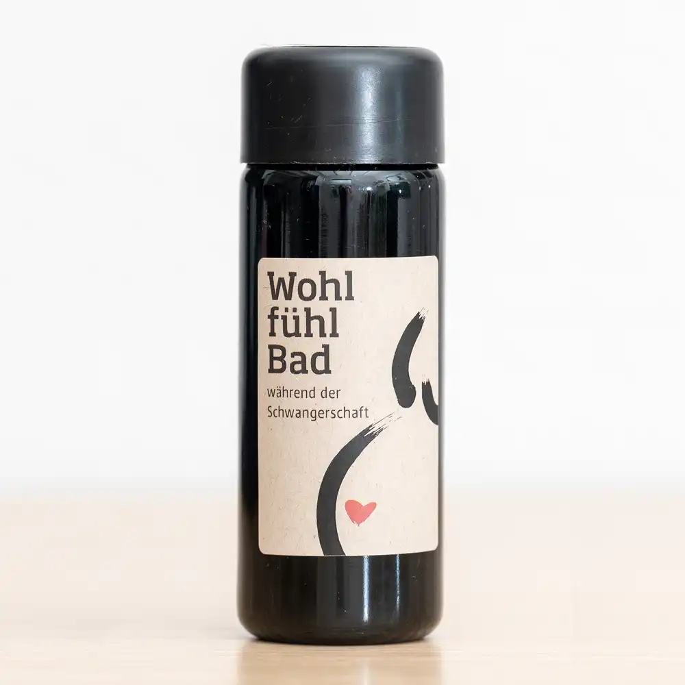 Dark bottle with a beige label reading 'Wohlfühl Bad' and a small red heart, indicating a pregnancy care bath product