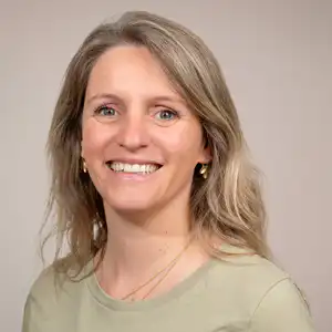 Profilbild-capucine-lehmann 💓 Härzchlopfä Hebamme 💓 Härzchlopfä Hebamme Portrait of a Smiling Woman with Shoulder Length Blonde Hair Wearing a Light Green Top Against a Neutral Beige Background Härzchlopfä Hebamme Härzchlopfä Hebamme
