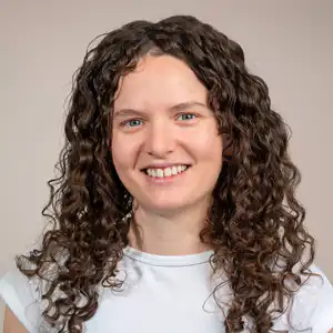Profilbild-lisa-beyeler 💓 Härzchlopfä Hebamme 💓 Härzchlopfä Hebamme Portrait of a Smiling Woman with Shoulder Length Curly Brown Hair Wearing a Light Top Against a Neutral Backdrop Härzchlopfä Hebamme Härzchlopfä Hebamme